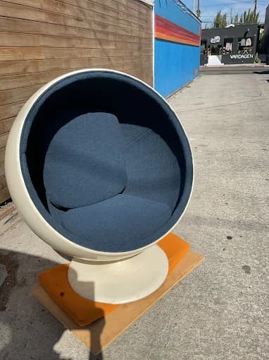 White ball chair with navy cushions photographed outdoors