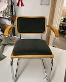 Chrome cantilever chair with wood accents and dark upholstery