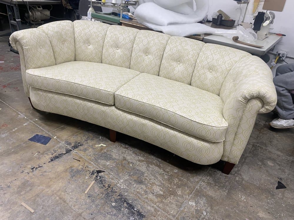 Curved button-tufted sofa in a cream and green geometric fabric