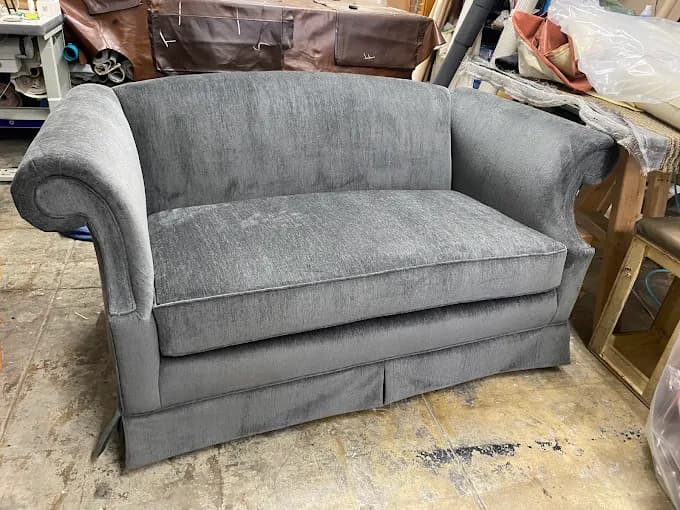 Custom gray velvet loveseat with skirted base
