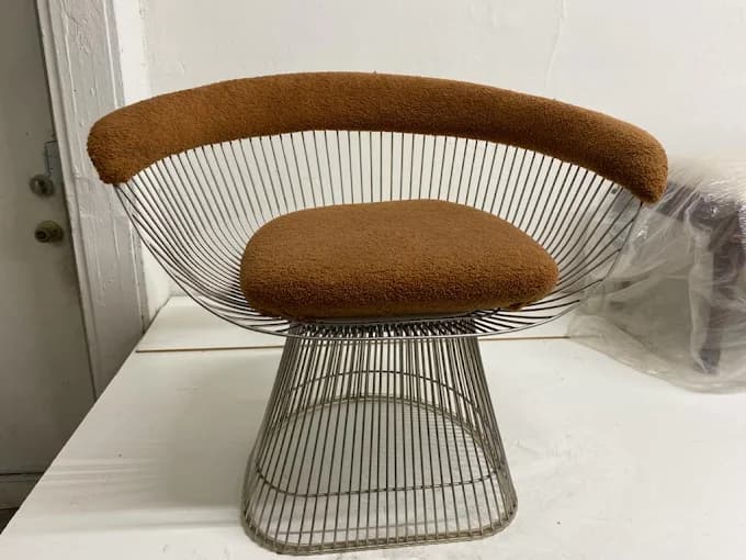 Chrome wire-frame chair with rust bouclé upholstery